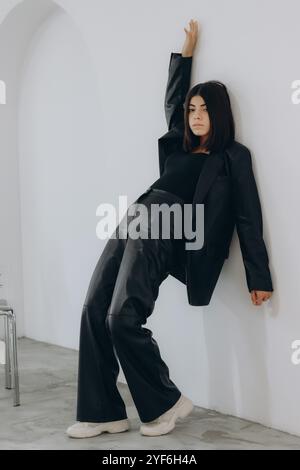 Young girl in black clothes posing. Women with short hair. A man in full growth. Model with short hair posing. Stock Photo