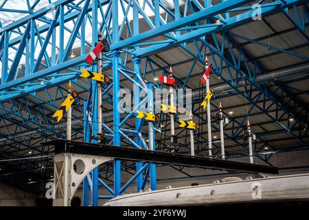 A group of historic semaphore rail signals on a gantry in the UK with lower quadrant signalling Stock Photo