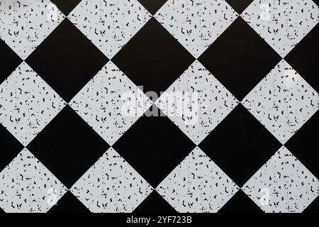 Checkerboard black and white floor tiles set on a diagonal pattern. Stock Photo