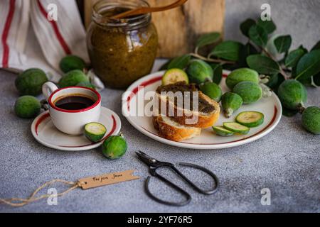 Close-up of a cup of black coffee and sliced white sourdough bread with feijoa jam on a table Stock Photo
