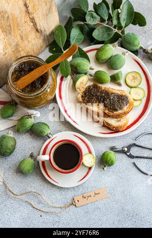 Overhead view of a cup of black coffee and sliced white sourdough bread with feijoa jam on a table Stock Photo