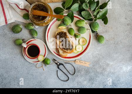 Overhead view of a cup of black coffee and sliced white sourdough bread with feijoa jam on a table Stock Photo