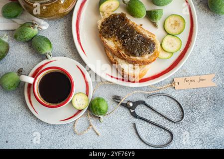 Overhead view of a cup of black coffee and sliced white sourdough bread with feijoa jam on a table Stock Photo