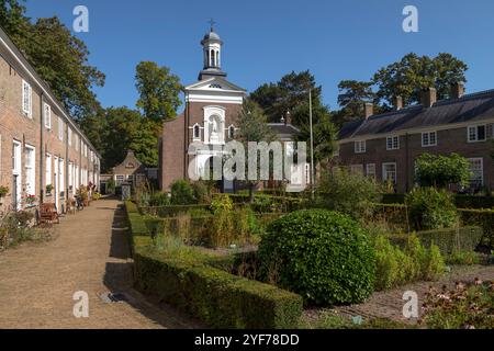 Beguinage in Breda with 29 houses around a herb garden with the Saint Catherine Church in the background in the Netherlands. Stock Photo