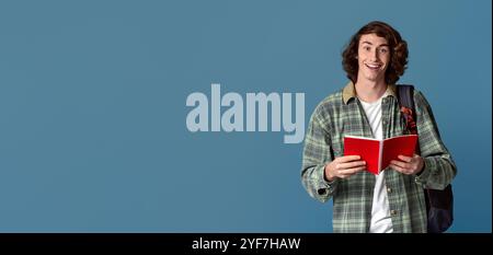 Back to school. Happy student with open notebook and backpack on turquoise background Stock Photo