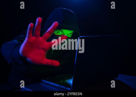 Computer Hacker in Hoodie. Obscured Dark Face. Hacker Attack, Virus Infected Software, Dark Web and Cyber Security Concept . Stock Photo