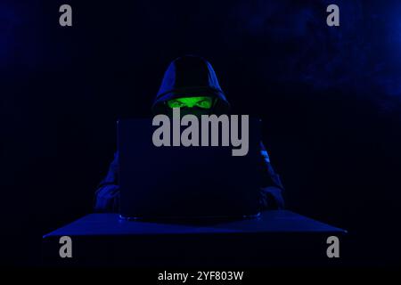 Computer Hacker in Hoodie. Obscured Dark Face. Hacker Attack, Virus Infected Software, Dark Web and Cyber Security Concept . Stock Photo