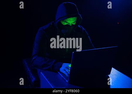 Hackers wear hoods to cover their faces. Hacking to steal important information. Use a computer to release malware viruses Ransom and harass organizat Stock Photo