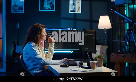 Cybersecurity expert using computer and augmented reality to look for company security vulnerabilities and injected malware. Programmer installing code on PC, looking at AR visualization, camera A Stock Photo