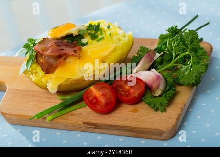 Tasty potato stuffed with eggs, bacon, cheese Stock Photo