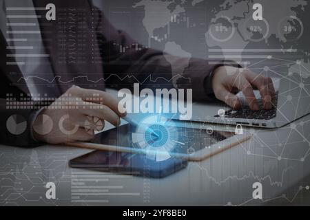 Technology and business. Man working on devices at table and graphs with schemes, double exposure Stock Photo