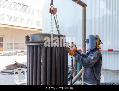 Technician argon welding parts of boiler, reparing old boiler in workshop. Stock Photo