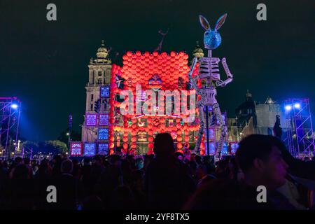 A vibrant Day of the Dead altar with illuminated decorations and skeletons lights up Zócalo at night, Mexico City. Dia de Muertos. Stock Photo