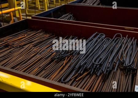 Steel rods or bars used to reinforce concrete, in warehouse at the metalworking shop. Modern industrial enterprise. Stock Photo