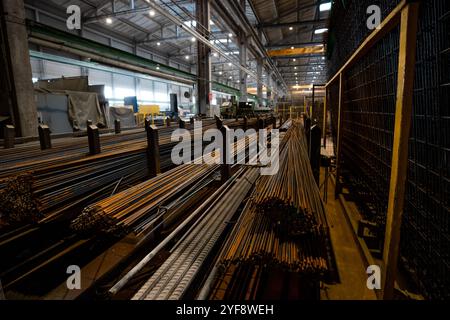 Steel rods or bars used to reinforce concrete, in warehouse at the metalworking shop. Modern industrial enterprise. Stock Photo