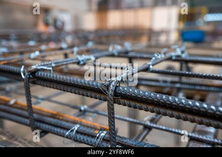 Steel rods or bars used to reinforce concrete, in warehouse at the metalworking shop. Modern industrial enterprise. Stock Photo