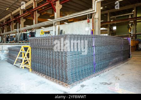 Steel rods or bars used to reinforce concrete, in warehouse at the metalworking shop. Modern industrial enterprise. Stock Photo