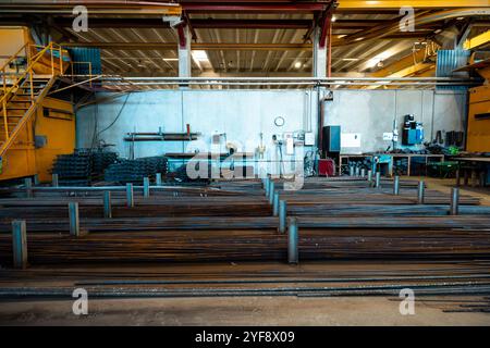 Steel rods or bars used to reinforce concrete, in warehouse at the metalworking shop. Modern industrial enterprise. Stock Photo