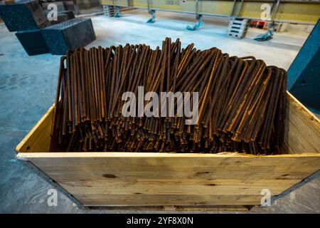 Steel rods or bars used to reinforce concrete, in warehouse at the metalworking shop. Modern industrial enterprise. Stock Photo