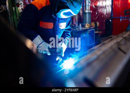 Metal welding steel works using electric arc welding machine to weld steel at factory. Metalwork manufacturing and construction maintenance service by Stock Photo