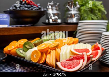 Assorted Fresh Fruits Display on a Buffet with Desserts and Utensils, Elegant Catering Concept in hotel Stock Photo