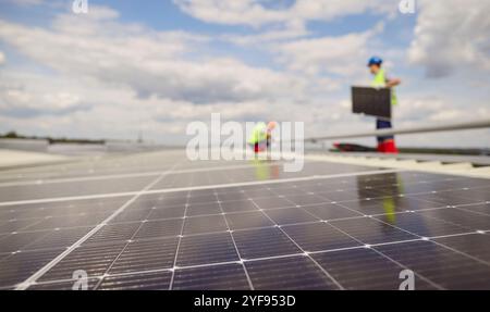 Electricians Installing Or Maintaining Solar Panels On Roof Stock Photo