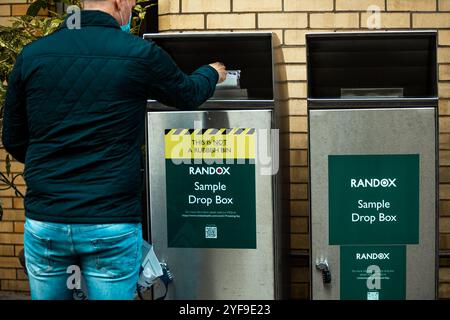 London, UK. september 20, 2022. Coronavirus sample drop box of Randox on city street next to fire service center and potted plant Stock Photo