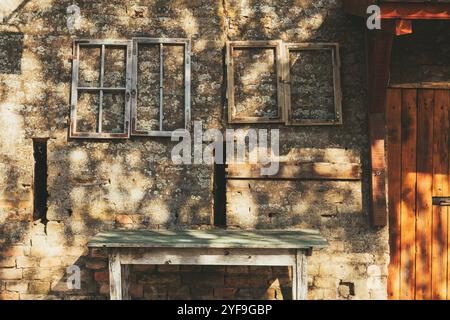 Old wooden table and window frames against the ruined brick wall as background Stock Photo