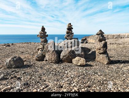 Amazing landscape with lava stone towers, balanced stacked rocks on rocky ground in front of ocean, Betancuria, Fuerteventura, Canary Islands, Spain Stock Photo