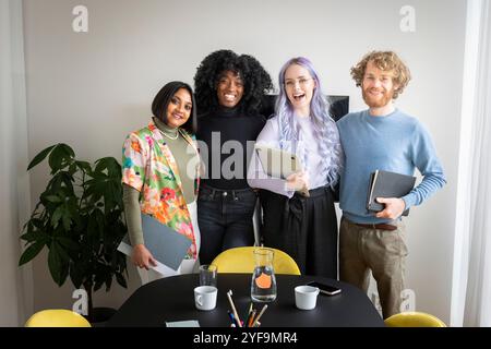 Portrait of happy male and female business professionals standing with each other in conference room Stock Photo