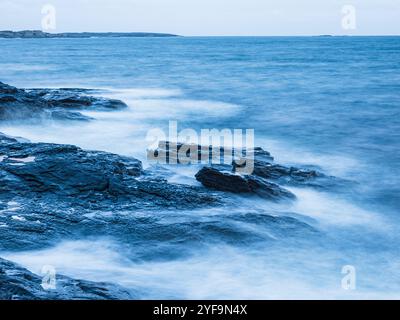 Waves breaking on rocks in sea Stock Photo