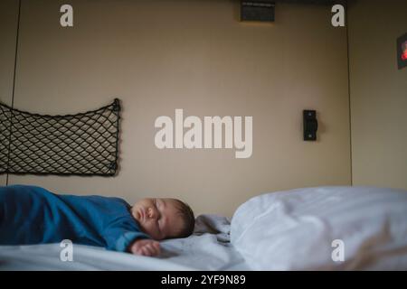 Side view of boy sleeping in passenger train Stock Photo