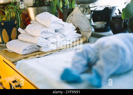 Stack of folded reusable cloth diapers on table Stock Photo
