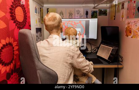 Rear view of father carrying son while using computer at home Stock Photo