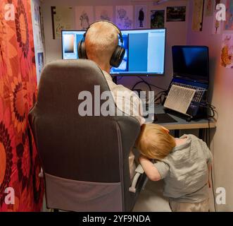 Boy standing by chair while father working at home office Stock Photo