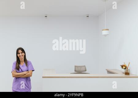 Optometrist smiling with arms crossed in her office Stock Photo