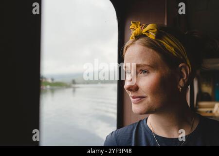Close-up of thoughtful woman looking through window in ferry Stock Photo
