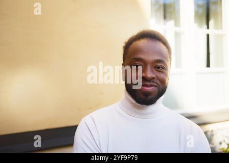 Portrait of smiling young man near wall Stock Photo
