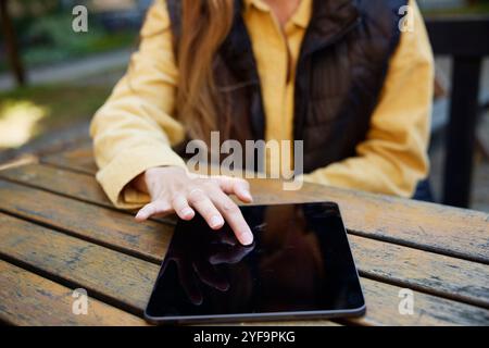 Midsection of female building contractor touching tablet PC kept on table Stock Photo