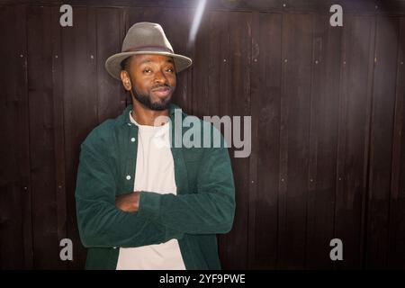 Portrait of confident young man with crossed arms standing against wall Stock Photo