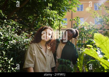 Portrait of multiracial friends standing amidst plants in park Stock Photo