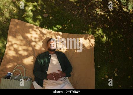 High angle view of young man sleeping on mat in park Stock Photo