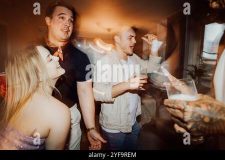 Friends enjoying drink while dancing at party Stock Photo
