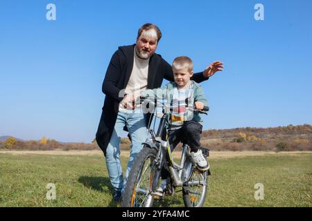 Learning to ride: a fun father-son experience Stock Photo