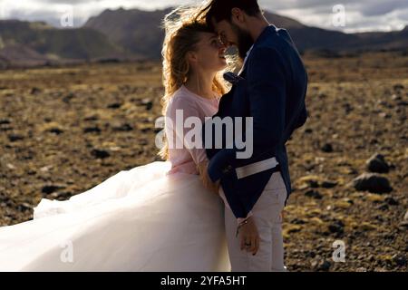 The groom kisses the bride in the mountains of Iceland. Stock Photo