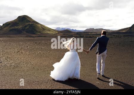 Couple in wedding suits in Iceland against the mountains Stock Photo