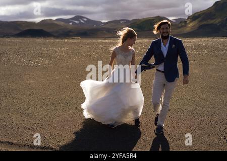 Couple in wedding suits in Iceland against the mountains Stock Photo