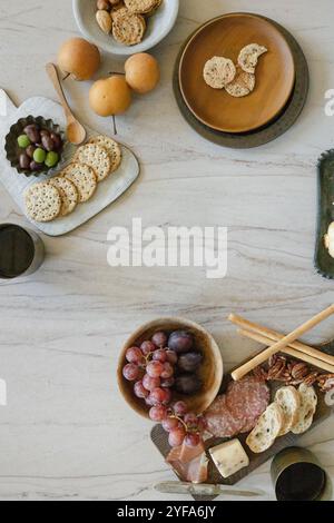 Charcuterie spread with fruit, nuts, cheese, and crackers on a table Stock Photo