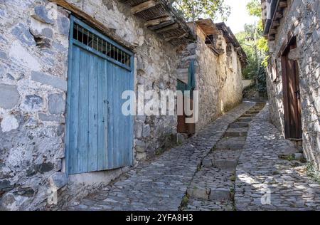 Stoned footpath crossing a traditional village. Stoned houses with wooden doors. Vintage architecture. Palaichori village, Cyprus, Europe Stock Photo