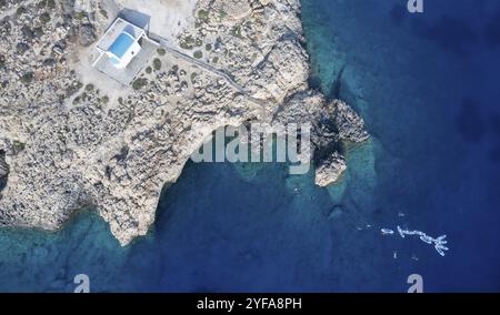 Drone aerial photograph of Cape Greco peninsula with Agioi Anargyroi christian church on the rocks. Turquoise ocean water Stock Photo